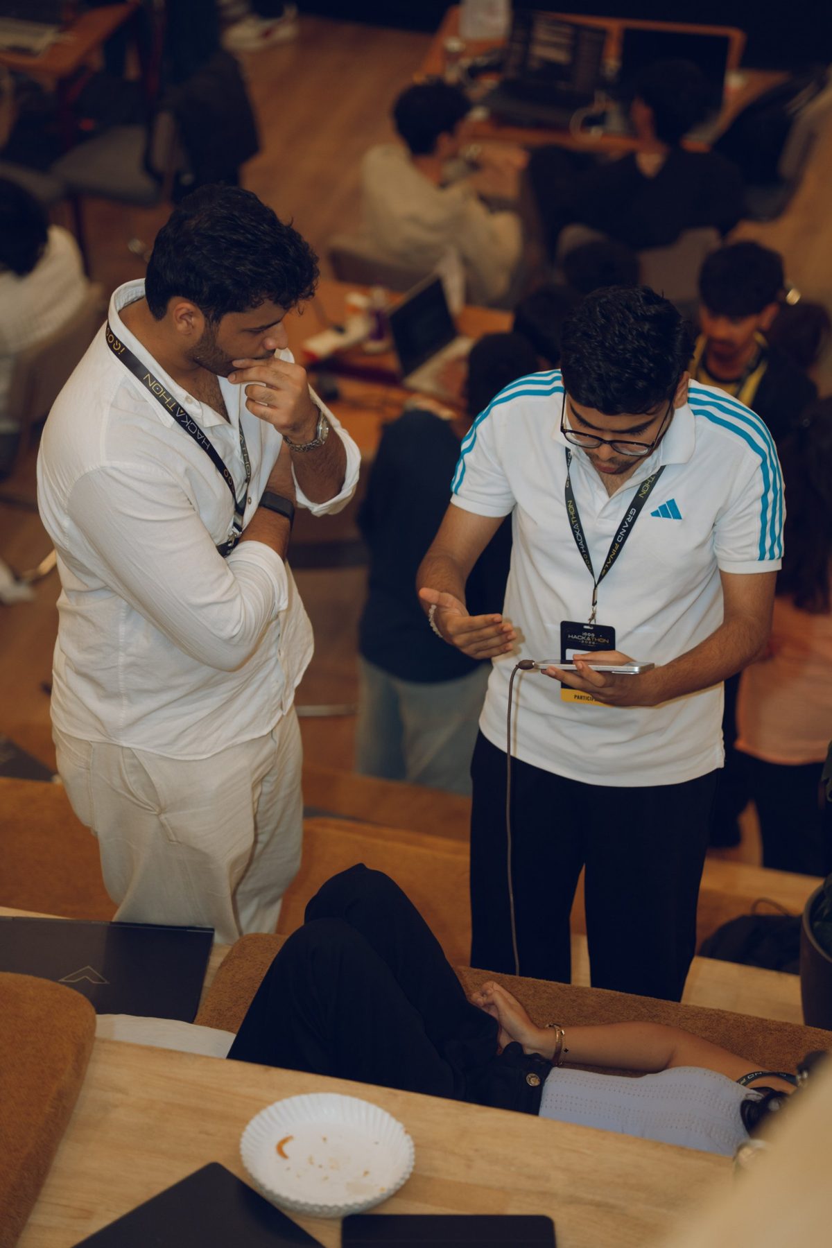 Shaswat Naman showing the Sanjeevani app on his phone to a teammate at the iQOO Hackathon Grand Finale